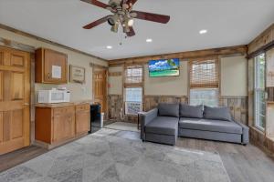 a living room with a couch and a ceiling fan at Cabin with Character in New Lexington