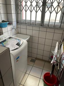 een badkamer met een wasmachine en een raam bij Apartamento Central Edifício Vale do Reno BC in Balneário Camboriú