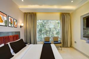 a bedroom with a bed and a large window at Hotel O namaste doon in Rājpur