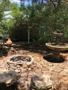 un patio in pietra con una fontana e rocce di Mystic Hill Suites a Cloptins Crossing Altre 3 foto