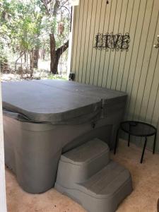 una vasca da bagno situata all'esterno di una casa con un tavolo di Mystic Hill Suites a Cloptins Crossing