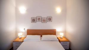 a bedroom with a large bed with two lights on it at Li Chessi Blu Villetta Familiare con Piscina in Costa Paradiso +37 photos