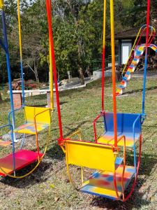 two colorful swings sitting in a yard at Hospedagem Famíliar in Cotia