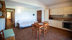 a kitchen and dining room with a table and chairs at Li Chessi Blu Villetta Familiare con Piscina in Costa Paradiso