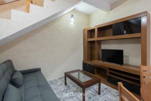 ItajubáにあるCasas completas em condomínio com piscina a 110m do Mar - ONIsのソファとテレビのあるリビングルーム