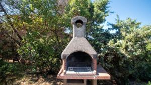 a bird feeder sitting in front of some trees at Li Chessi Blu Villetta Familiare con Piscina in Costa Paradiso
