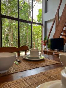 comedor con mesa y vistas a los árboles en Itacaré Ecolodge, en Itacaré