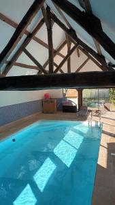 a large blue swimming pool in a building at Les 2 Ginkgos à 5 minutes de Beauval in Seigy