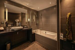 a bathroom with a sink and a bath tub and a sink at Hôtel Le Parc - La Table de Franck Putelat in Carcassonne +31 photos
