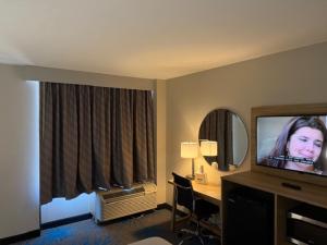 Days Inn by Wyndham Amarillo East في أماريلو: غرفة في الفندق مع تلفزيون ومكتب مع جهاز كمبيوتر