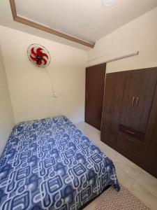 a bedroom with a bed and a clock on the wall at Casa Familiar 2 quartos em Búzios in Búzios