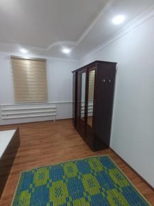 ヌクスにあるХостел18Аの黒いキャビネットとラグのある空の部屋