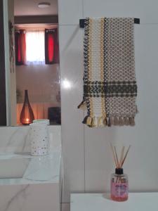 a curtain on a wall with a vase on a table at Casa Familiar 2 quartos em Búzios in Búzios +27 photos