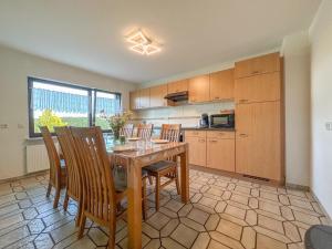a kitchen with a wooden table and chairs at Eifelleben Kleinlangenfeld in Kleinlangenfeld