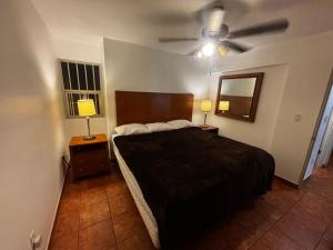 ein Schlafzimmer mit einem Bett und zwei Nachttischen mit Lampen in der Unterkunft Casa Tampico in Tijuana