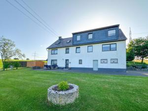 a large white house with a plant in a yard at Eifelleben Kleinlangenfeld in Kleinlangenfeld