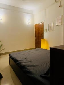 a bedroom with a bed and a wooden door at StelaCasa Homestay in Tezpur