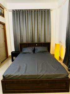 a large bed in a bedroom with a curtain at StelaCasa Homestay in Tezpur