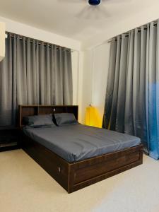 a bed in a bedroom with black curtains at StelaCasa Homestay in Tezpur