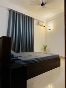 a bedroom with a bed and a blue curtain at StelaCasa Homestay in Tezpur