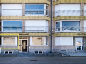 an apartment building with a door and a balcony at Zeezicht GV in Galopen