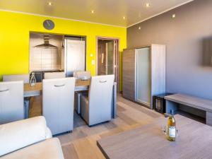 a room with a kitchen with yellow walls and a table at Zeezicht GV in Galopen