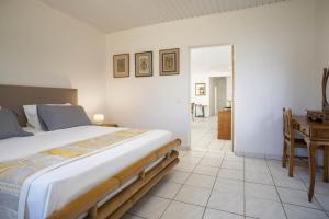 a bedroom with a large bed and a table at Fare Bambridge in Pirae
