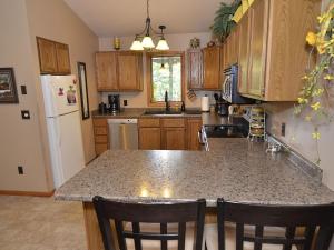 a kitchen with a granite counter top and wooden cabinets at Ole and Lena's Place in Bayfield