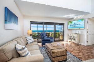 a living room with a couch and a tv at Bandy Beach D201- Gulf Front Luxury in Sanibel