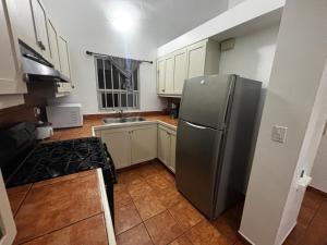 eine Küche mit einem Edelstahlkühlschrank und weißen Schränken in der Unterkunft Casa Tampico in Tijuana