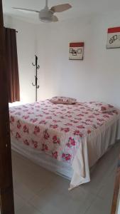 a bedroom with a bed with a cross on the wall at Chalé Zarinha I in Serra Negra +56 photos