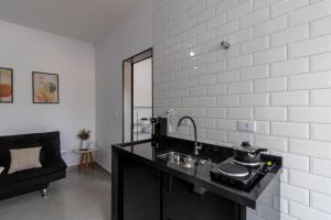 a kitchen with a sink and a counter top at 0804 Orquídea Studio Próx GRU e Estação Cecap in Guarulhos +40 photos