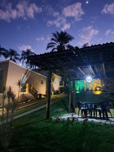 a patio with a table in a yard at night at Chalé Zarinha I in Serra Negra