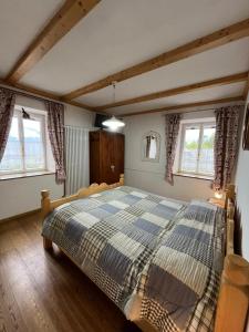 a bedroom with a large bed in a room with windows at Casa Gabry in Varena