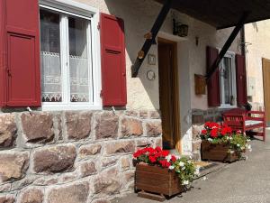 a house with red shutters and flowers on the porch at Casa Gabry by Sunhome Fiemme in Varena +2 photos