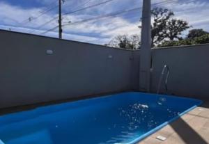 a blue swimming pool on a white fence at aconchegante com piscina e churrasqueira, pertinho da praia" in Itapoa