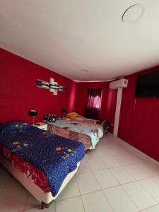 two beds in a room with red walls at Alisos Suite FC in El Ceibal +14 photos