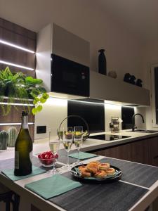 a kitchen with a plate of food and two glasses of wine at Residenza Ai Berici in Vicenza