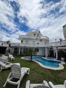 a large house with a swimming pool and chairs at Alisos Suite FC in El Ceibal