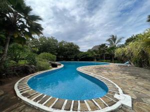 a swimming pool with a path around it at CASA GRACE in Malindi