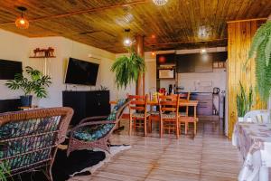 a dining room and kitchen with a table and chairs at Cabana Raízes - LaCabanasEco in Chapecó