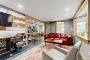 a living room with a red leather couch and a table at The River House in West Wardsboro