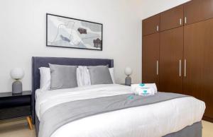 1 dormitorio con 1 cama blanca grande y armarios marrones en Luxury home, en Abu Dabi