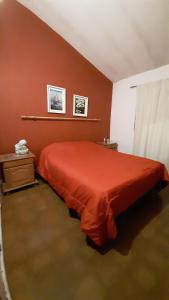 a bedroom with a red bed in a room at Casa Los Abuelos in La Granja