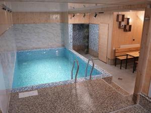 a large swimming pool in a room with a table at Continental Hotel & Sauna in Vanadzor