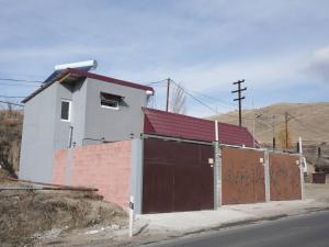 un edificio blanco con una puerta marrón con grafitis. en Continental, en Vanadzor