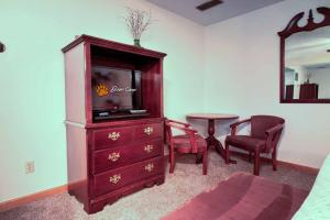 a living room with a tv and a dresser at Bear Camp By The Night in Pigeon Forge