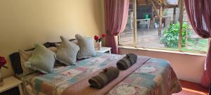 Un dormitorio con una cama con almohadas y una ventana. en 7atSapele, en Germiston 2 fotos más