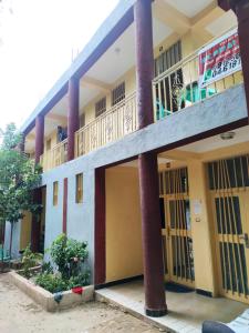 阿尔巴门奇Arba Minch hiber Guest house的庭院内有一座带柱子和门的建筑。