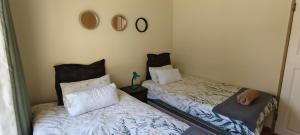 Dos camas una al lado de la otra en una habitación. en 7atSapele, en Germiston